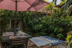 einen Tisch und Stühle unter einem Sonnenschirm auf einer Terrasse in der Unterkunft Gheller Apartment in Verona