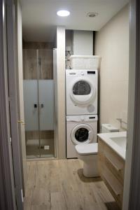 a bathroom with a washing machine and a toilet at B&B LOS LLANOS in Estella