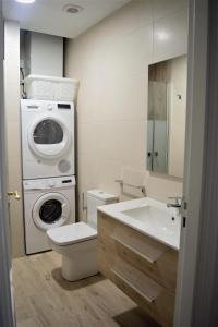 B&B LOS LLANOS في إستيلا: حمام مع غسالة ومرحاض ومغسلة