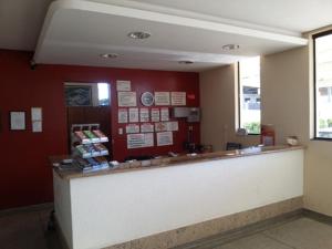 a waiting room with a counter and a red wall at Hotel Gran Valle in Registro