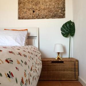 Dormitorio con cama, lámpara y planta en Casa da Pedra - Aljezur, always the sun, en Aljezur