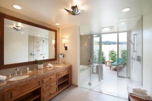 a bathroom with a sink, mirror, and bathtub at Quail Lodge & Golf Club in Carmel