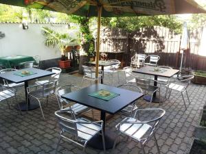 a patio with tables and chairs and an umbrella at Penzion Pohoda Beroun in Beroun