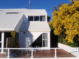 a house with a balcony and a roof at BEACH FRONT:Palms-on-the-beach.KAITERITERI. in Kaiteriteri