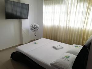 a room with a bed and a flat screen tv at Hotel Avenida El Bosque in Floridablanca