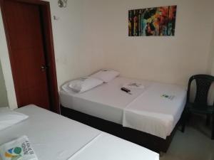 Habitación con 2 camas y una foto en la pared. en Hotel Avenida El Bosque, en Floridablanca