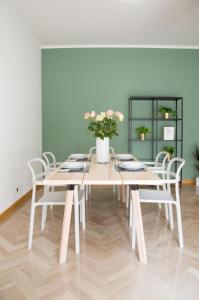 a table with white chairs and a vase with flowers at Piedaterre sulle Mura - Treviso to Venice in Treviso +10 photos