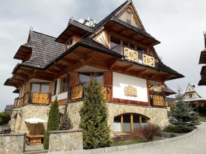 a large wooden house with a gambrel roof at Tatrachata Studio in Kościelisko