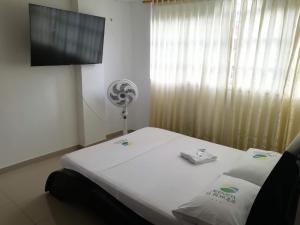 a hospital room with a bed and a flat screen tv at Hotel Avenida El Bosque in Floridablanca