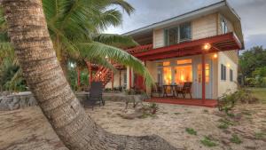 ein Haus am Strand mit einer Palme in der Unterkunft Tia Maria Retreat in Rarotonga
