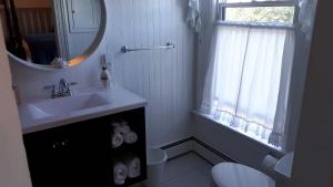 a white bathroom with a sink and a mirror at Hillside Landing B&B in Digby