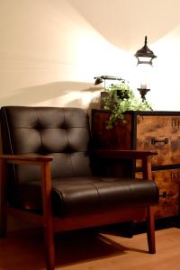 a leather chair sitting in a room with a lamp at Origami Residential Suite - Tokyo Asakusa Skytree in Tokyo