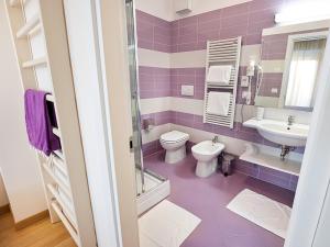 a purple bathroom with a toilet and a sink at Hotel Sporting in San Benedetto del Tronto