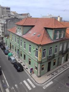 un gran edificio verde con techo rojo en una calle en Hostel Matosinhos Suites, en Matosinhos