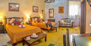 a hotel room with two beds and a chair at Hotel Convento Santa Catalina by AHS in Antigua Guatemala
