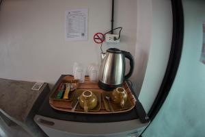 a tea kettle on a tray on top of a refrigerator at The Ele Hotel Ranong - SHA Extra Plus in Ranong