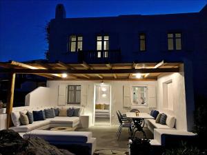 een patio met banken en een tafel voor een huis bij Healthy House Mykonos in Ornos