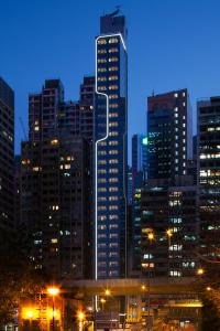 eine Skyline der Stadt in der Nacht mit hohen Gebäuden in der Unterkunft CM+ Hotels and Serviced Apartments in Hongkong