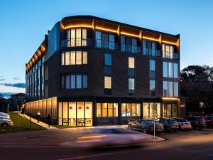 堪培拉阿多比金斯顿酒店的前面停着汽车的建筑物