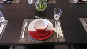 a table with a red and white plate and fork and knife at La Casa de Los Milagros in San Miguel de Allende