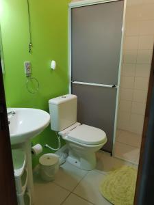 La salle de bains est pourvue de toilettes, d'un lavabo et d'une douche. dans l'établissement Suítesmariscal Suítes Mariscal, à Bombinhas