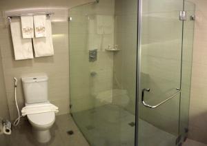a bathroom with a toilet and a glass shower at The Plaza Hotel Balanga City in Balanga