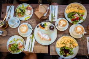 a wooden table with plates of food on it at Alaya Verde Bed & Breakfast in Ringtail Creek