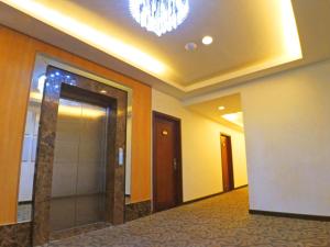 un corridoio di un hotel con specchio e ascensore di The Plaza Hotel Balanga City a Balanga