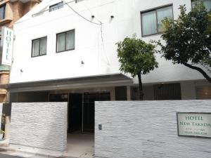 a white building with a sign in front of it at Hotel New Takada in Tokyo