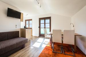 a living room with a dining room table and a couch at Appartements Tannenhof in Wagrain