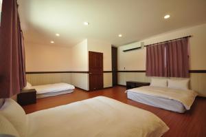 a hotel room with two beds in a room at Seasons Homestay in Xiaoliuqiu