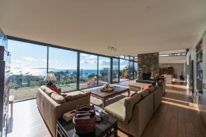 a living room with couches and a large window at Dragonfly Lodge in Swansea