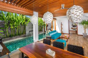 a living room with a pool and a table and chairs at S18 Bali Villas in Legian