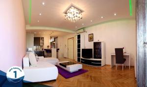 a living room with a white couch and a table at NFM Apartman in Osijek