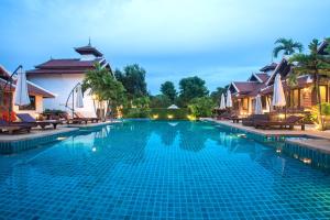 a swimming pool at a resort at night at Achawalai Residence Village By Song in Jomtien Beach