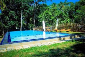a swimming pool in a yard with two picnic tables at Talalla Freedom Resort in Talalla