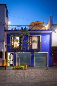 una casa azul con un árbol delante en Hotel Casa Frida en Cuernavaca