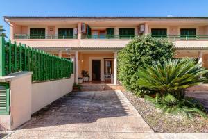 a house with a fence and a walkway at Llac Gran in Port d'Alcudia