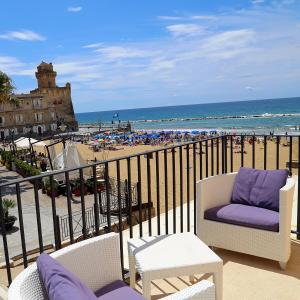 een balkon met 2 stoelen en uitzicht op het strand bij Palazzo Iaquinto in Santa Maria di Castellabate