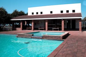 a swimming pool in front of a building at Laguna 75 in Uvongo Beach