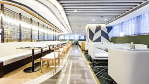 eine Reihe von Tischen und Stühlen in einem Restaurant in der Unterkunft Hotel COZi Oasis in Hongkong
