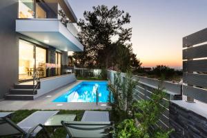 a swimming pool in the backyard of a house at Nisos Villa, walking distance to the beach & shops, By ThinkVilla in Sfakaki