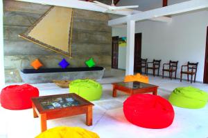 a living room with red and green spheres and tables at Villa 45 - Balapitiya in Balapitiya