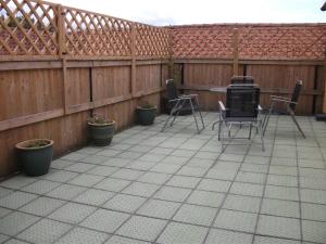 a patio with chairs and a table and a fence at Valentino's in Filey