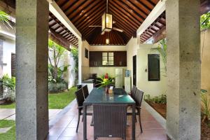an outdoor dining room with a table and chairs at Askara Villa in Canggu