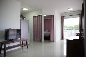 uma sala de estar com uma televisão de ecrã plano e um espelho em Grandbeach A31 by malai em Mae Pim