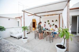 a group of people sitting at a table on a patio at Ortigia Boutique Terrace apt in Syracuse