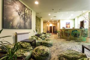 a lobby with green plants and a painting on the wall at Hotel Perun Lodge in Bansko