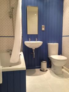 a blue bathroom with a sink and a toilet at The Store, harbour holiday cottage in Port Seton