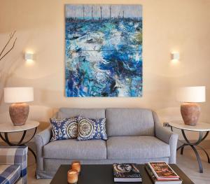 a living room with a couch and a painting at Trafalgar Polo Club in El Palmar